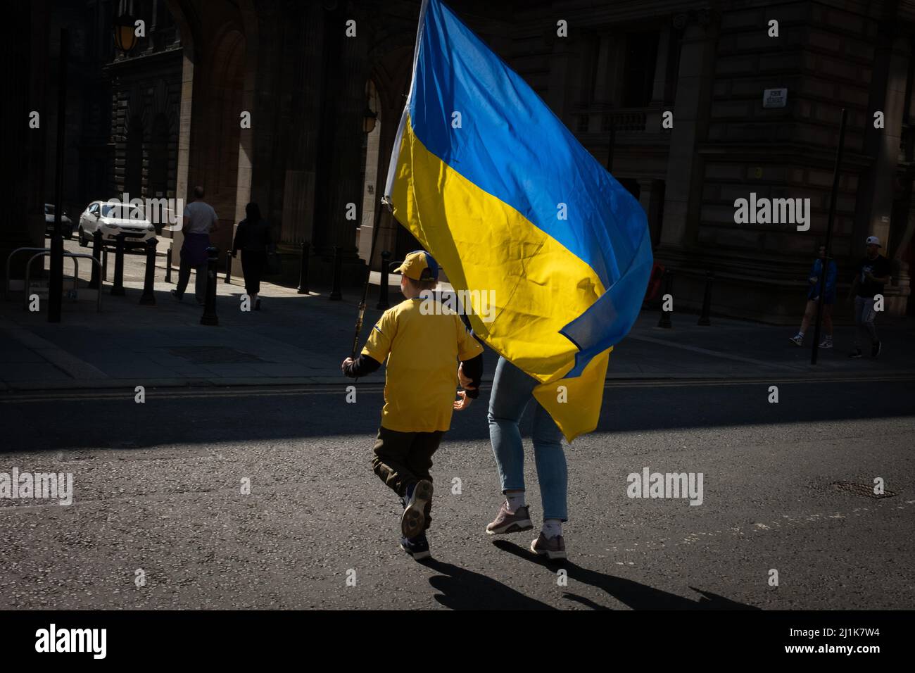 Glasgow, Schottland, 26.. März 2022. Eine ukrainische Familie, mit der blauen und gelben ukrainischen Flagge, macht sich auf den Weg zum George Square für die Kundgebung mit der Ukraine zur Unterstützung ihres Landes in seinem aktuellen Krieg gegen die Invasion von Präsident PutinÕs Russland, in Glasgow, Schottland, 26. März 2022. Foto: Jeremy Sutton-Hibbert/Alamy Live News. Stockfoto