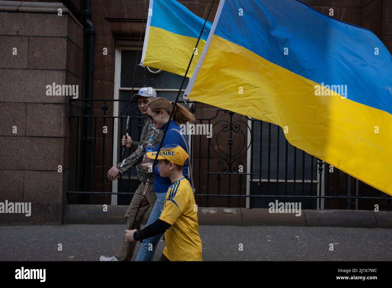 Glasgow, Schottland, 26.. März 2022. Eine ukrainische Familie, mit der blauen und gelben ukrainischen Flagge, macht sich auf den Weg zum George Square für die Kundgebung mit der Ukraine zur Unterstützung ihres Landes in seinem aktuellen Krieg gegen die Invasion von Präsident PutinÕs Russland, in Glasgow, Schottland, 26. März 2022. Foto: Jeremy Sutton-Hibbert/Alamy Live News. Stockfoto
