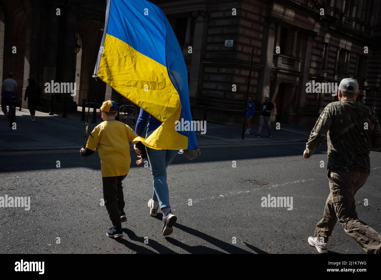 Glasgow, Schottland, 26.. März 2022. Eine ukrainische Familie, mit der blauen und gelben ukrainischen Flagge, macht sich auf den Weg zum George Square für die Kundgebung mit der Ukraine zur Unterstützung ihres Landes in seinem aktuellen Krieg gegen die Invasion von Präsident PutinÕs Russland, in Glasgow, Schottland, 26. März 2022. Foto: Jeremy Sutton-Hibbert/Alamy Live News. Stockfoto