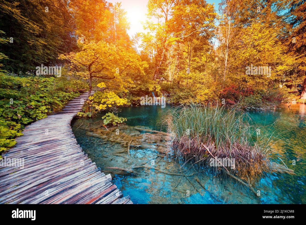 Majestätischer Blick auf den See mit türkisfarbenem Wasser und sonnigen Balken im Nationalpark Plitvicer Seen. Der Wald leuchtet durch Sonnenlicht. Kroatien. Europa. Dramatischer Morgen Stockfoto