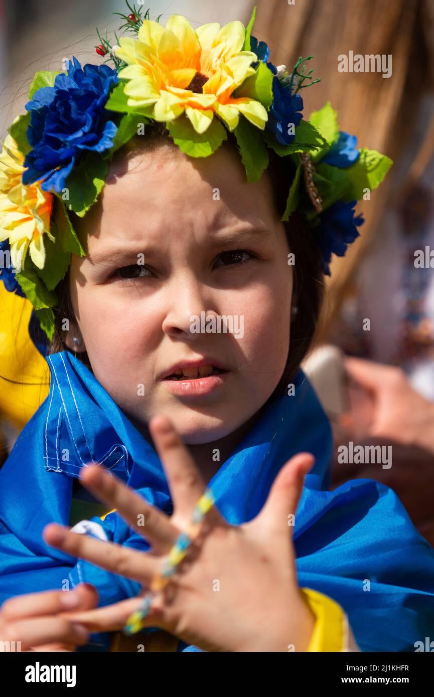 London, Großbritannien. 26. März 2022. Ein Mädchen mit traditionellen Blumen im Haar in ‘‘London steht mit der Ukraine’, ein solidaritätsmarsch von der Park Lane, vorbei am Piccadilly Circus, wo Yoko Onos Botschaft „IMAGINE PEACE“ gezeigt wird, zu einer Mahnwache auf dem Trafalgar Square. Der ukrainische Präsident Wolodymyr Zelenski hat an Menschen in der ganzen Welt appelliert, auf die Straße zu gehen, um die Ukraine zu unterstützen, um einen Monat nach der russischen Invasion zu demonstrieren. Kredit: Stephen Chung / Alamy Live Nachrichten Stockfoto