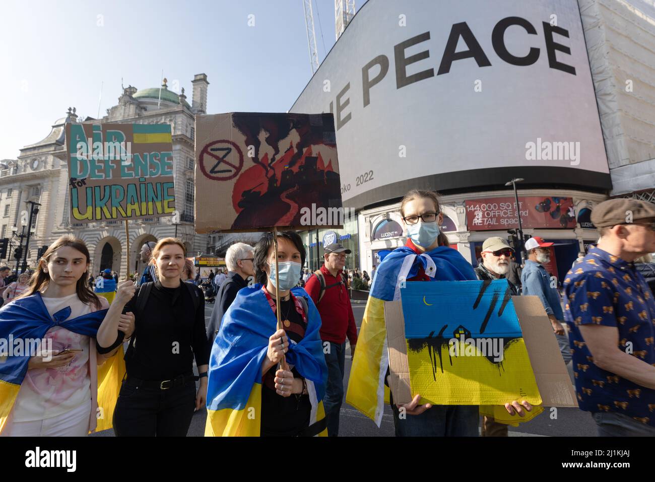 London, Großbritannien. 26. März 2022. London steht mit der Ukraine marsch in London am Piccadilly Circus, wo Yoko Onos Imagine Peace zur Unterstützung der Ukraine gegen die russische Invasion und den Krieg gezeigt wurde. Quelle: Andy Sillett/Alamy Live News Stockfoto