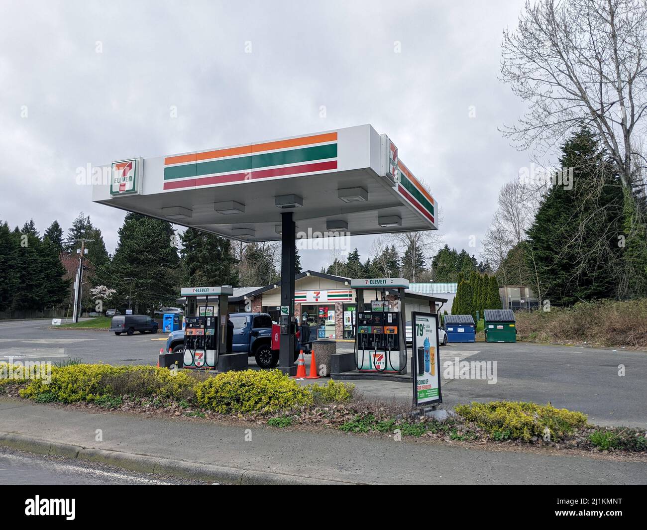 Kirkland, WA USA - ca. April 2021: Abgewinkelte Ansicht einer 7 Eleven Tankstelle an der Ecke einer kleinen Kreuzung. Stockfoto