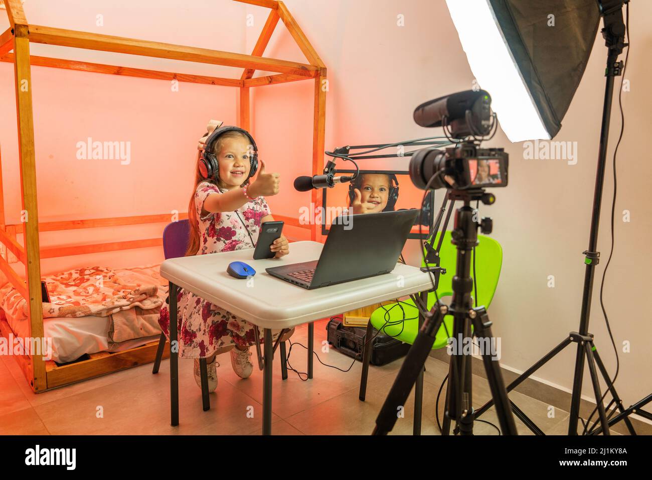 Glückliches Mädchen zu Hause Rundfunk Aufnahme Video für soziale Netzwerke mit Kamera und Stativ in ihrem Zimmer Stockfoto