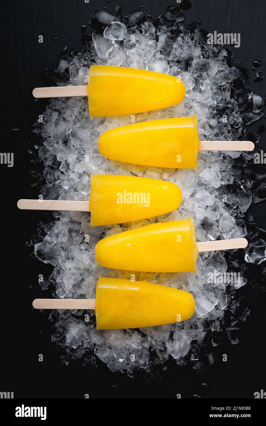 Fruchtorangen-Eis lolly auf einem schwarzen Tisch Stockfotografie - Alamy