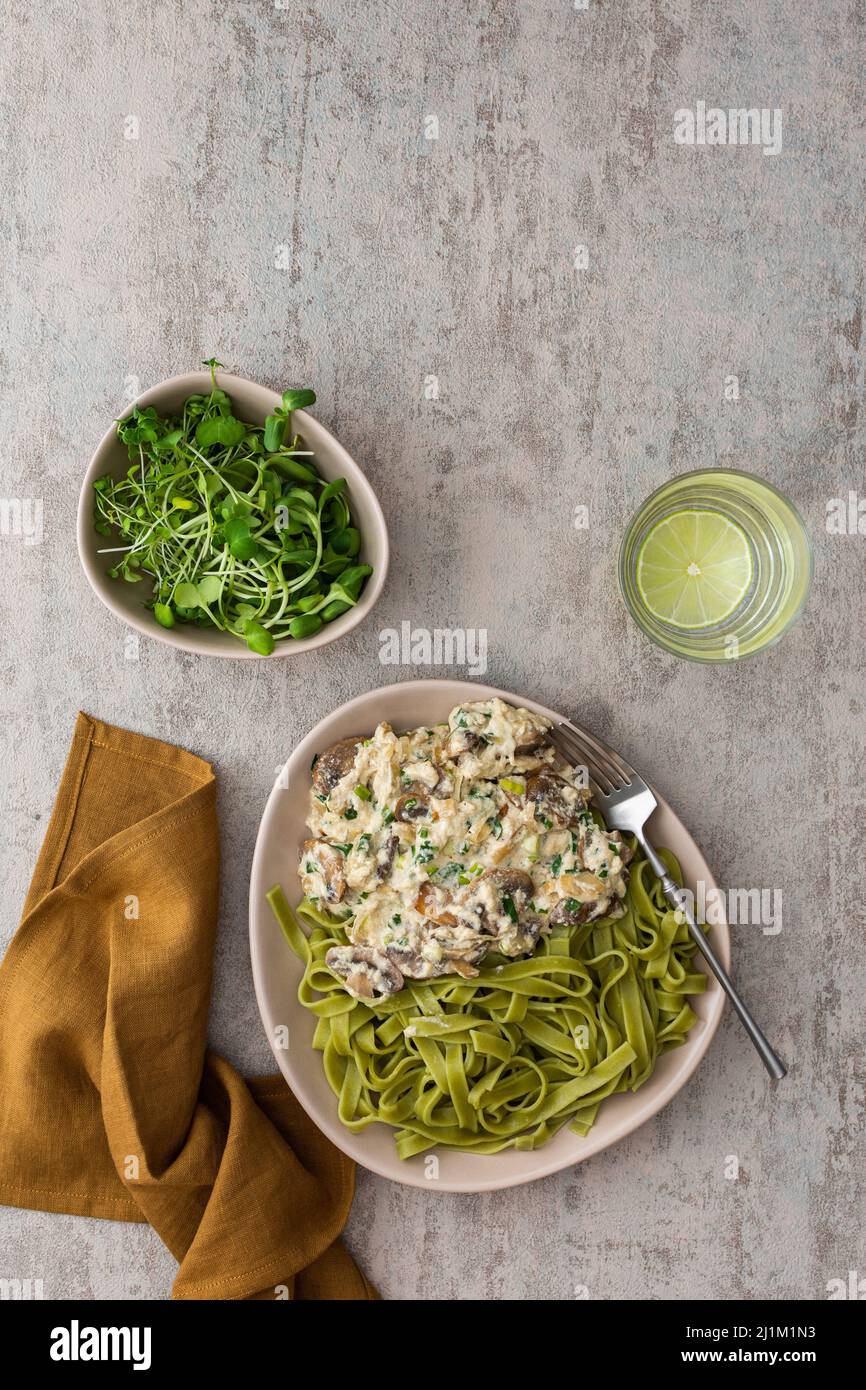 Grüne Pasta aus Hartweizen und Soße mit Champignons in saurer Rahmsoße ...