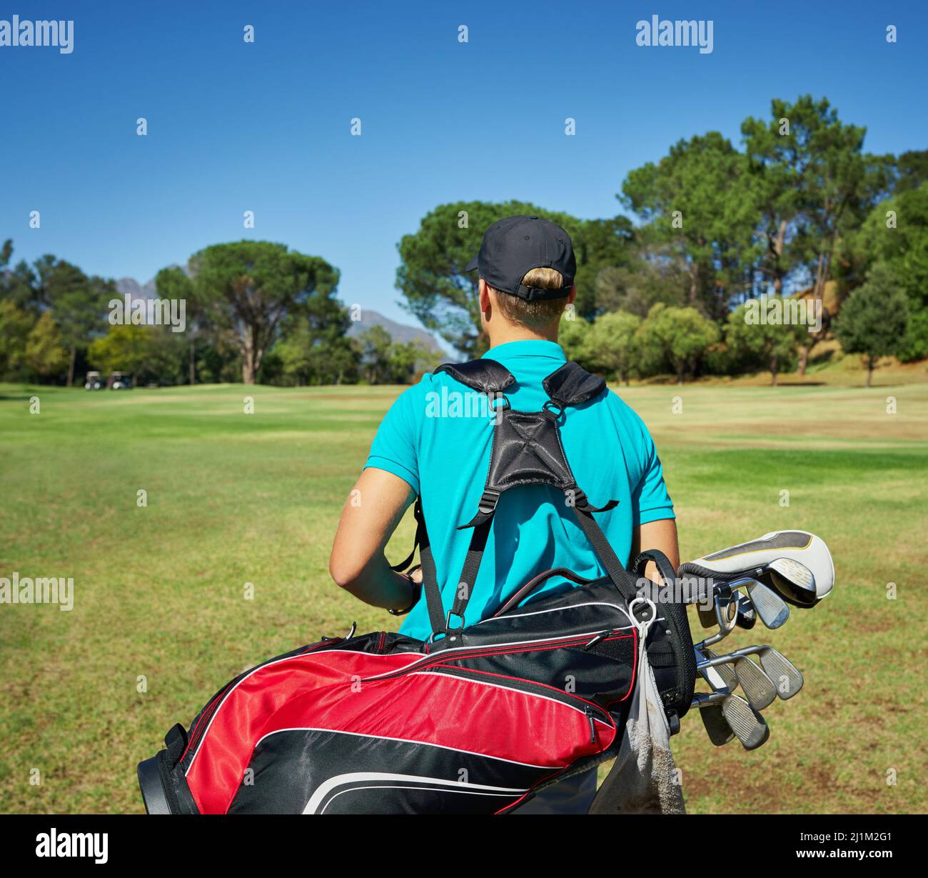Vorbereitet und bereit, Golf zu spielen. Aufnahme eines nicht erkennbaren jungen Mannes, der mit seiner Golfausrüstung draußen auf einem Golfplatz läuft. Stockfoto