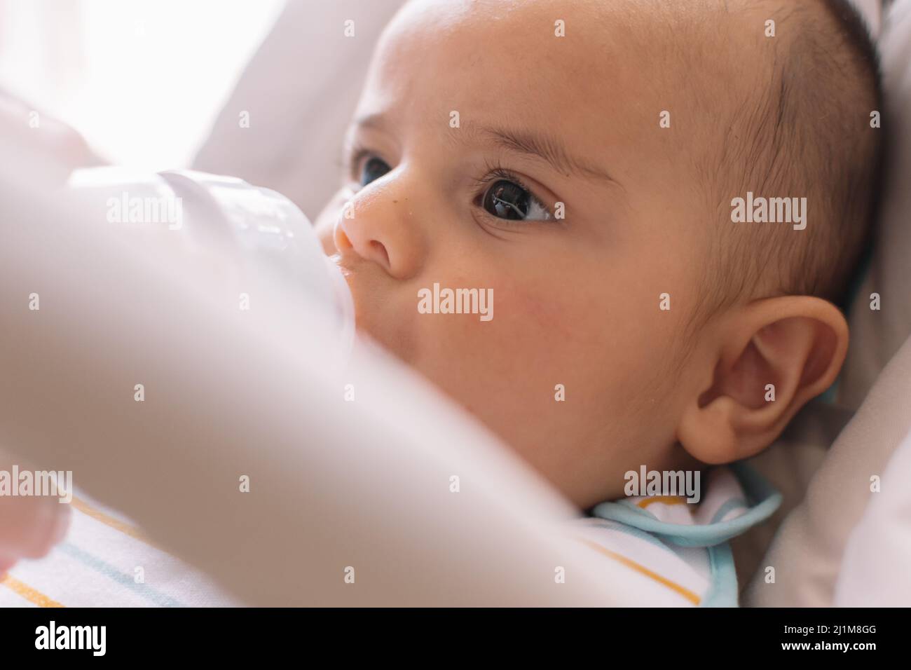 Baby trinkt Milch aus einer Milchflasche. Stockfoto