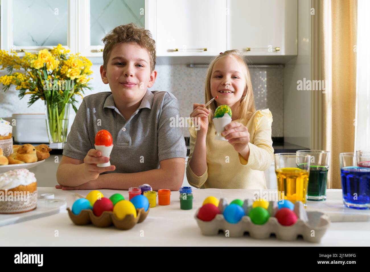 Lachende Bruder und Schwester malen ostereier. Stockfoto