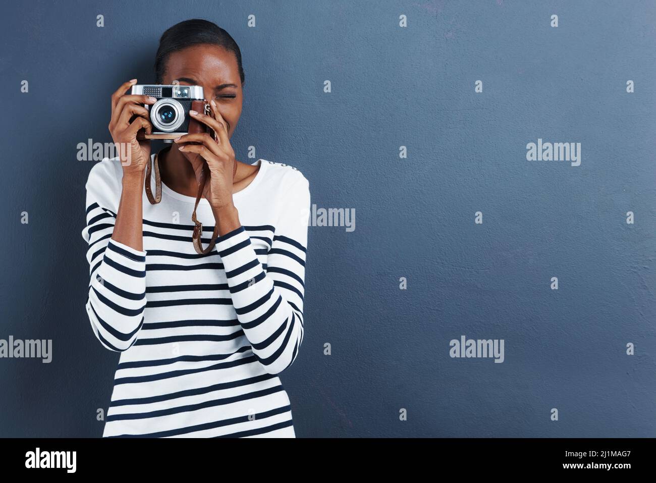 Lächeln. Aufnahme einer attraktiven jungen Frau, die mit einer Vintage-Kamera ein Foto macht. Stockfoto Lächeln. Aufnahme einer attraktiven jungen Frau, die mit einer Vintage-Kamera ein Foto macht. Stockfoto