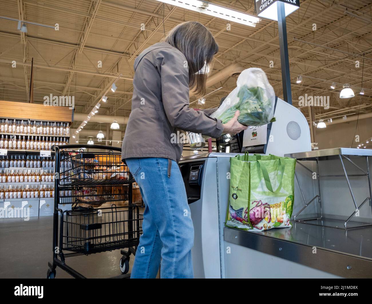 Lynnwood, WA USA - ca. März 2022: Ansicht einer Frau in einer grauen Jacke, die im Self-Checkout-Bereich eines Stadt- und Landmarktes auscheckte Stockfoto