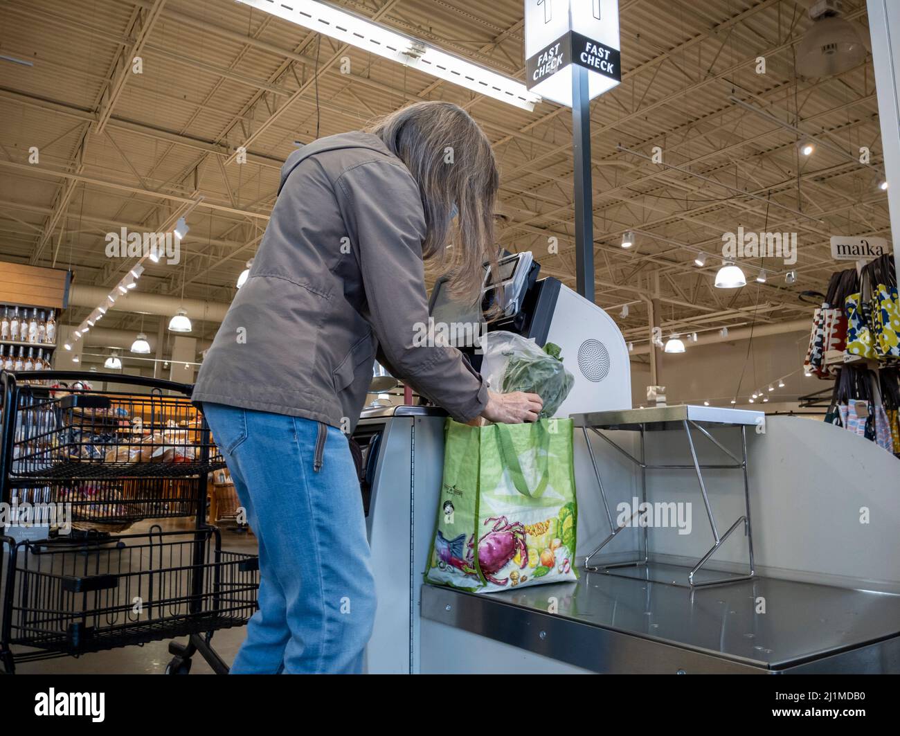 Lynnwood, WA USA - ca. März 2022: Ansicht einer Frau in einer grauen Jacke, die im Self-Checkout-Bereich eines Stadt- und Landmarktes auscheckte Stockfoto