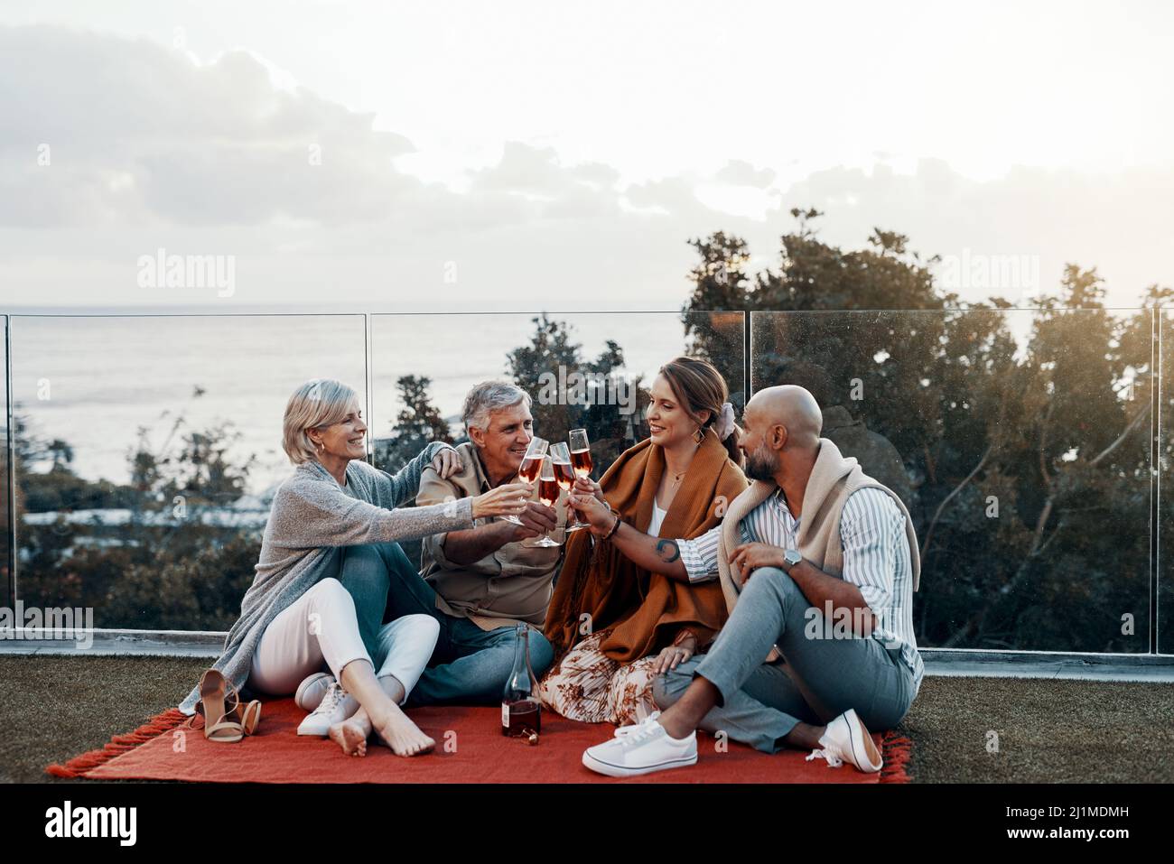 Heres zu vielen weiteren Jahresfeiern zusammen. In voller Länge eine liebevolle Familie, die beim Feiern mit ihren Weinläsern anstoss Stockfoto
