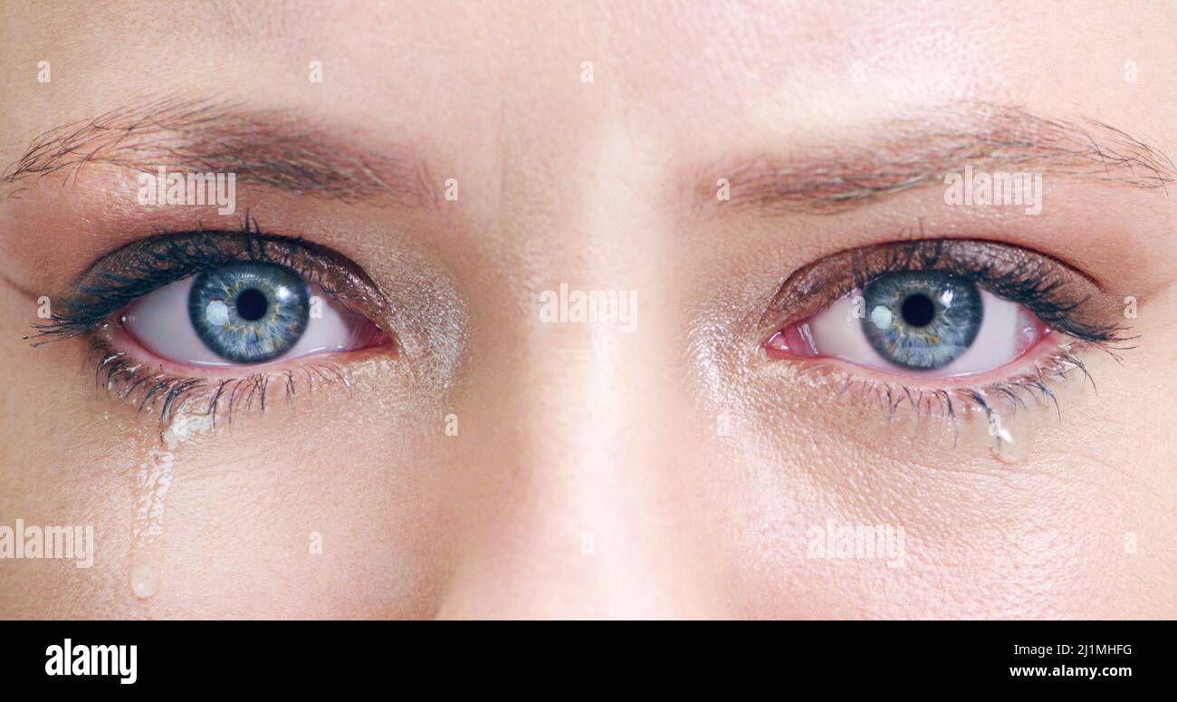Ich kann nicht verhindern, dass die Tränen in mein Gesicht fallen. Nahaufnahme einer jungen Frau mit Tränen in den Augen im Studio. Stockfoto