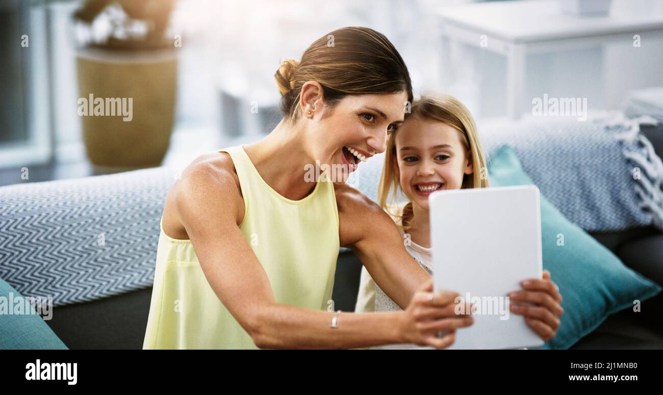 Teilen Sie die digitale Erfahrung mit meiner kleinen Prinzessin. Aufnahme einer schönen jungen Mutter und ihrer Tochter mit einem digitalen Tablet zusammen in der Stockfoto