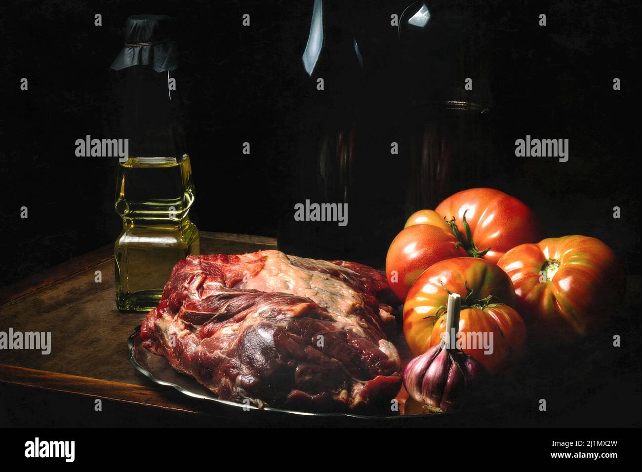 Bodegón de carne, Tomates, ajo, Aceit y Bandeja de plata. / Stillleben von Fleisch, Tomaten, Knoblauch, Öl und einem Silbertablett Stockfoto