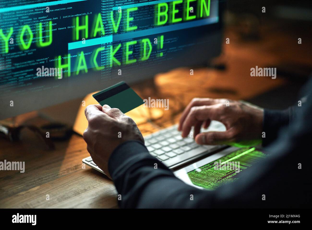 Jemand ist für eine böse Überraschung bereit. Ausgeschnittene Aufnahme eines nicht identifizierbaren Hackers, der im Dunkeln einen Computercode knackt. Stockfoto