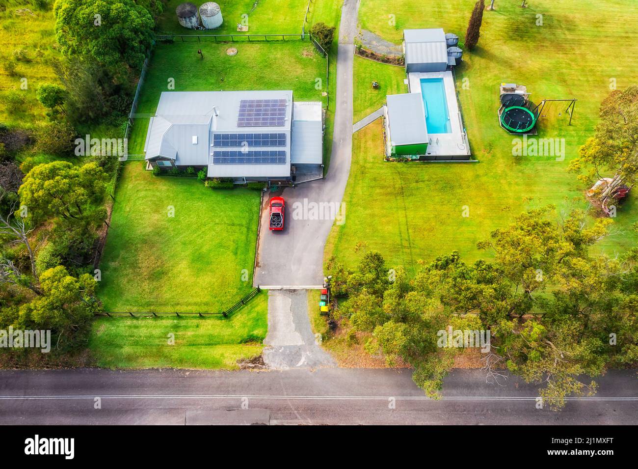 Grüne abgeschiedene Landwirtschaftsfarm an der Central Coast von Australien in Luftaufnahme von oben. Stockfoto