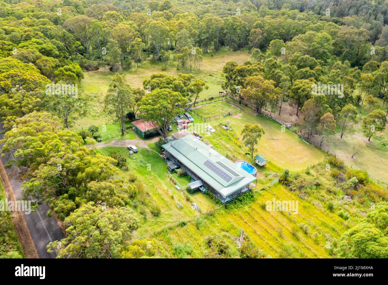 Abgeschiedene grüne Landwirtschaft Farm und Haus in Kaugummiwäldern an der australischen Zentralküste, Luftlandschaft. Stockfoto