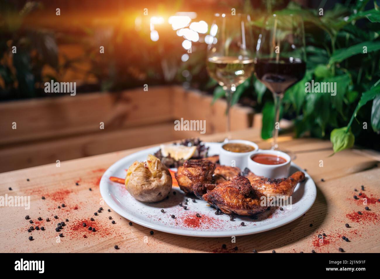 Georgische Küche Gericht gebratenes Huhn Tapaka auf dem Teller und Wein im Restaurant Stockfoto