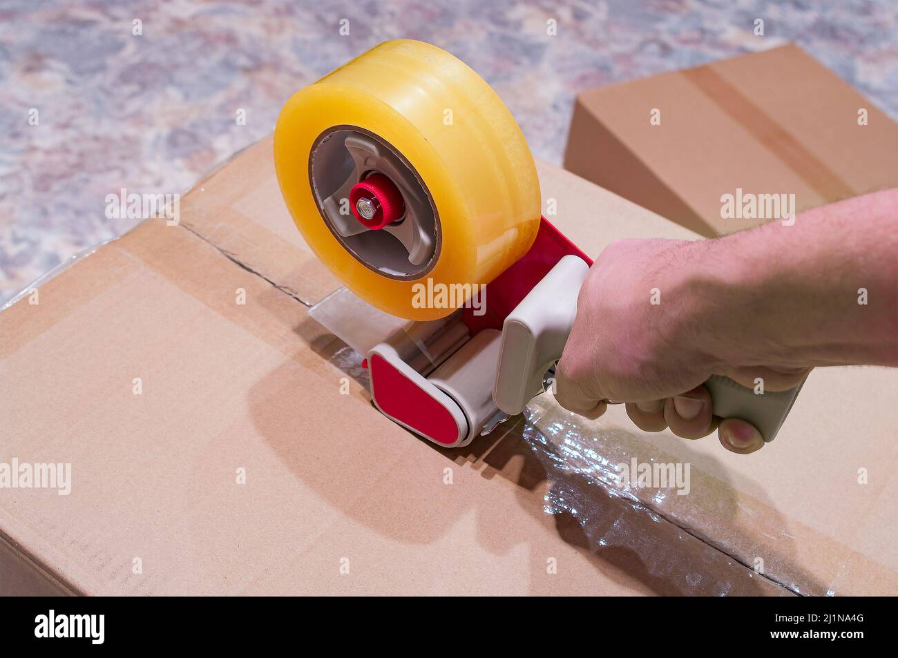 Verpackung von Paketen mit Scotch Tape Dispenser close-up Stockfoto