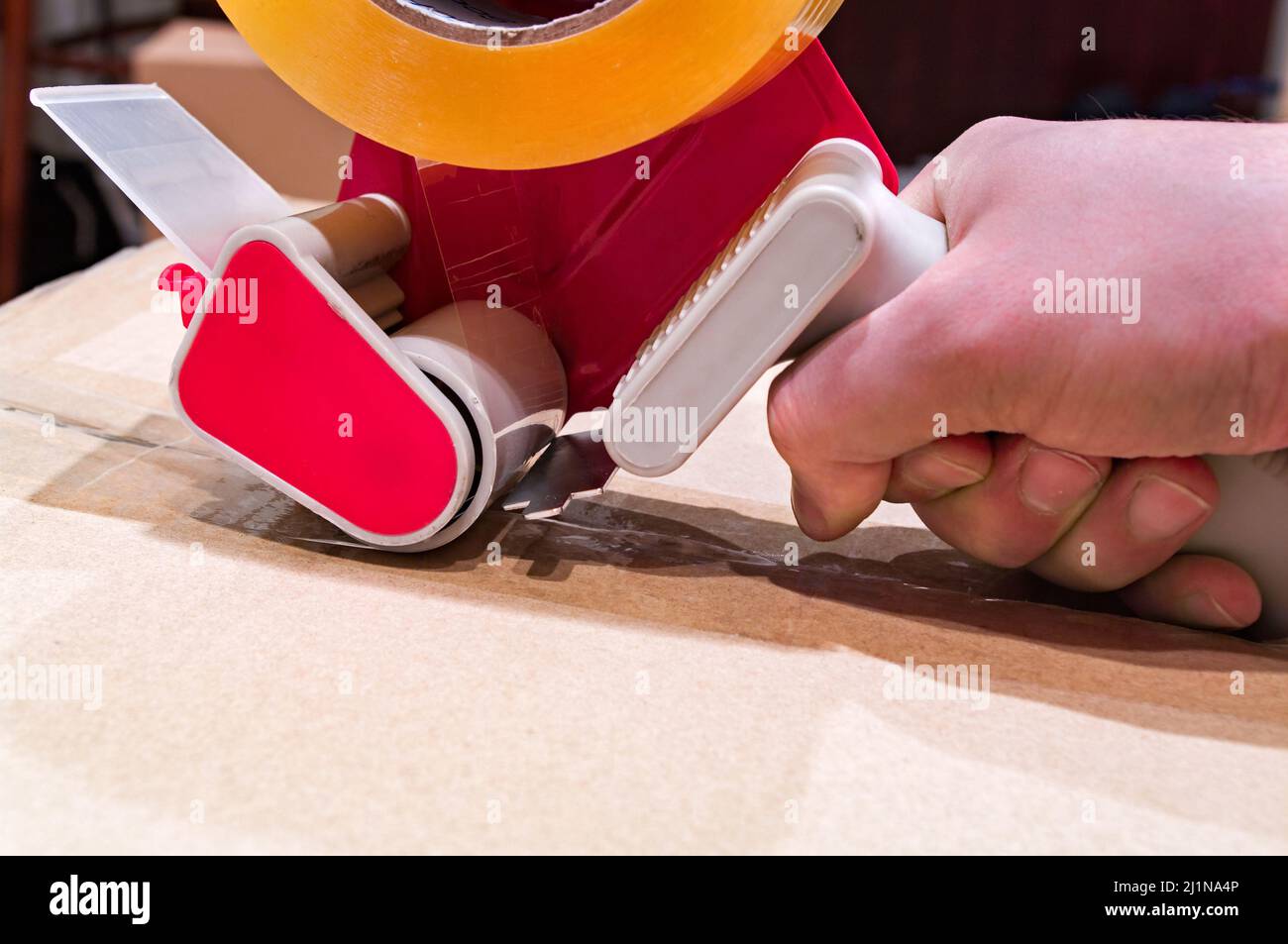 Verpackung von Paketen mit Scotch Tape Dispenser close-up Stockfoto