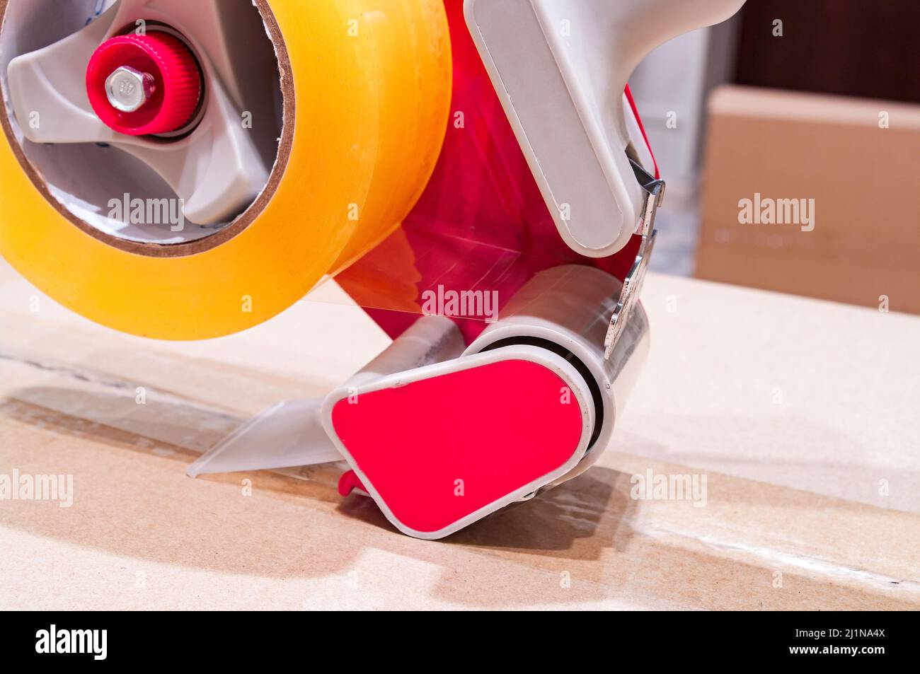 Verpackung von Paketen mit Scotch Tape Dispenser close-up Stockfoto