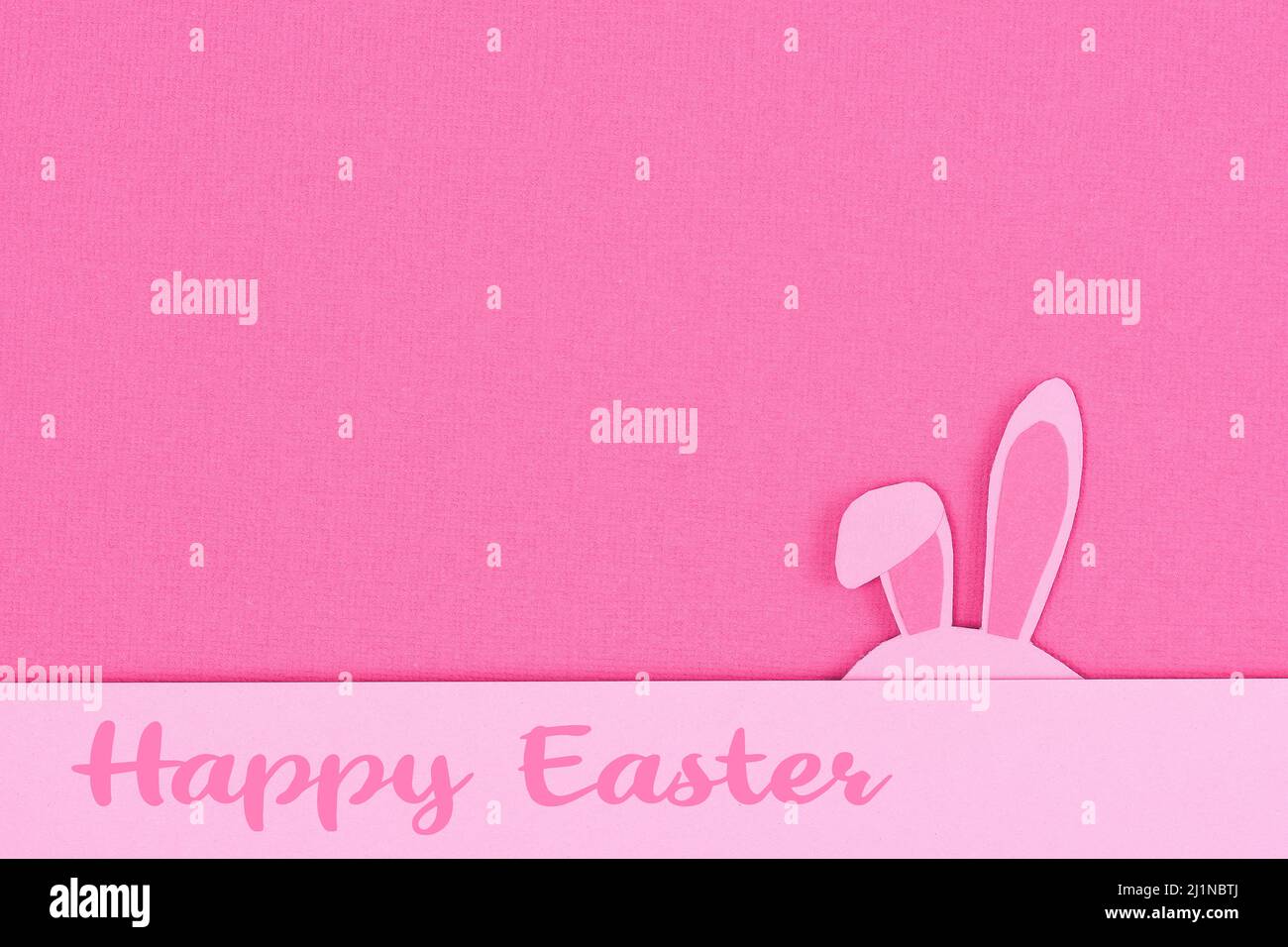 Hasenohren aus rosa Papier auf rosa Hintergrund. Papierschnitt aus buntem osterhase und blauer Eierform. Frohe ostern Grußkarte Vorlage. Stockfoto