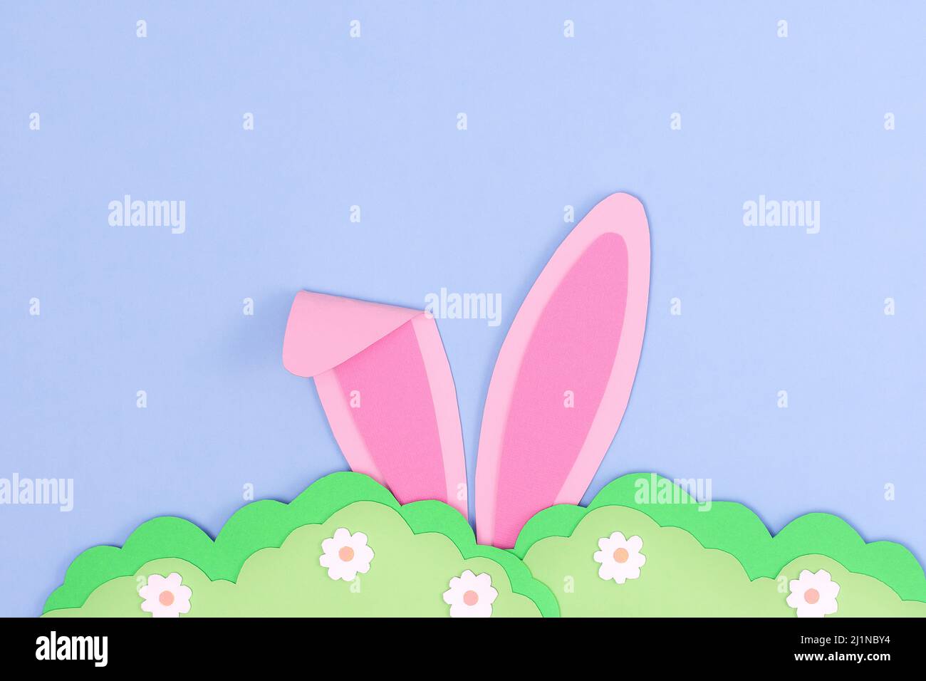 Hasenohren mit rosa Hasen und grünem Gras aus Papier. Frohe Ostern Tag Hintergrund mit Hase verstecken im Gras. Vorlage für Ostern-Grußkarten. Kreative EA Stockfoto