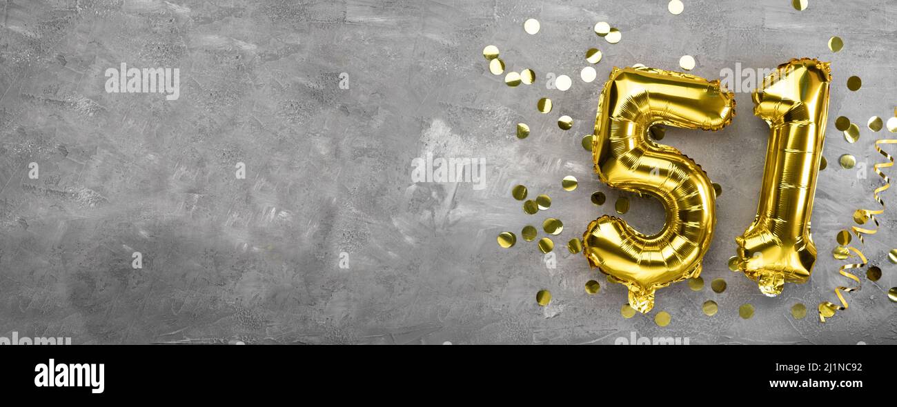 Gelbe Folienballon-Nummer, Zahl einundfünfzig Betonhintergrund. Grußkarte mit der Aufschrift 51. Jubiläumskonzept. Zum Jubiläum Stockfoto