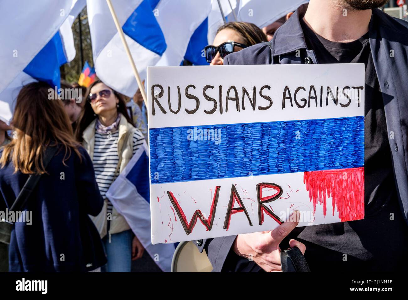 London, 26.. März 2022. Tausende von Menschen treten mit der Ukraine zusammen, marschieren und mahnten im Zentrum von London, um gegen die russische Invasion zu protestieren. Mitglieder der Bewegung gegen den Krieg schließen sich dem marsch an. Die Bewegung hat eine weiße und blaue Flagge als Symbol ihres Protests angenommen, die den roten Streifen der russischen Flagge ersetzt, um die Verbindung mit Blut und Gewalt sowie militärischer Macht und Autoritarismus zu beseitigen. Sie verweist auch auf die historische Flagge von Veliky Nowgorod, wo die Regierung der Republik Nowgorod den Ruf hatte, demokratische Regierungsführung zu entwickeln. Stockfoto