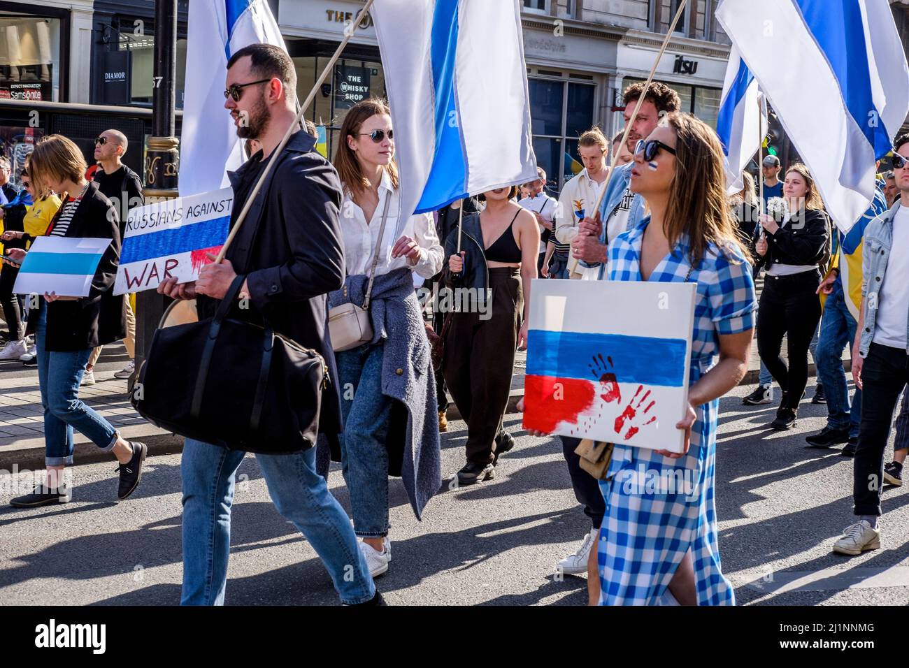 London, 26.. März 2022. Tausende von Menschen treten mit der Ukraine zusammen, marschieren und mahnten im Zentrum von London, um gegen die russische Invasion zu protestieren. Mitglieder der Bewegung gegen den Krieg schließen sich dem marsch an. Die Bewegung hat eine weiße und blaue Flagge als Symbol ihres Protests angenommen, die den roten Streifen der russischen Flagge ersetzt, um die Verbindung mit Blut und Gewalt sowie militärischer Macht und Autoritarismus zu beseitigen. Sie verweist auch auf die historische Flagge von Veliky Nowgorod, wo die Regierung der Republik Nowgorod den Ruf hatte, demokratische Regierungsführung zu entwickeln. Stockfoto