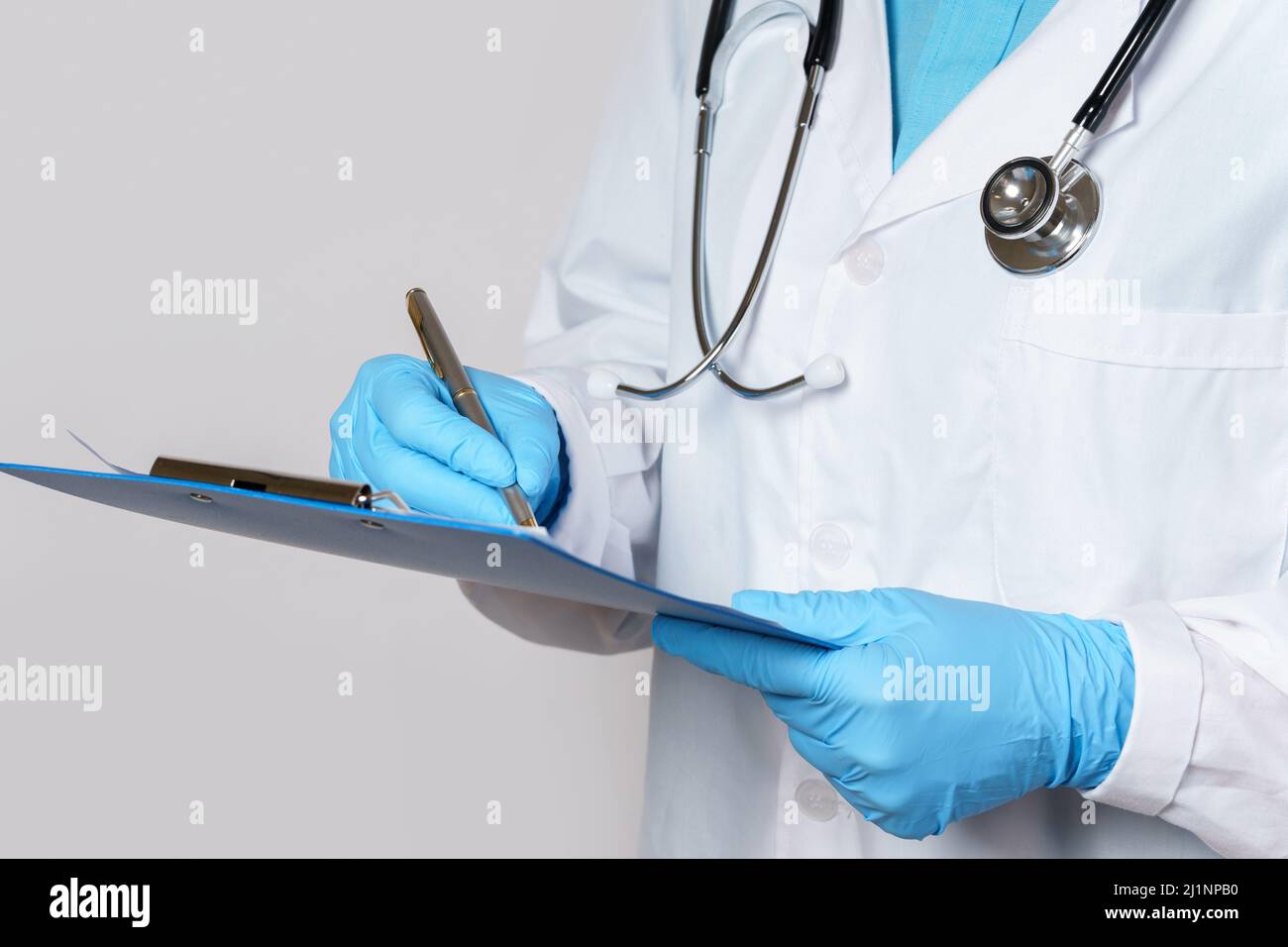 Arzt füllt einen medizinischen Bericht auf grauem Hintergrund aus Stockfoto