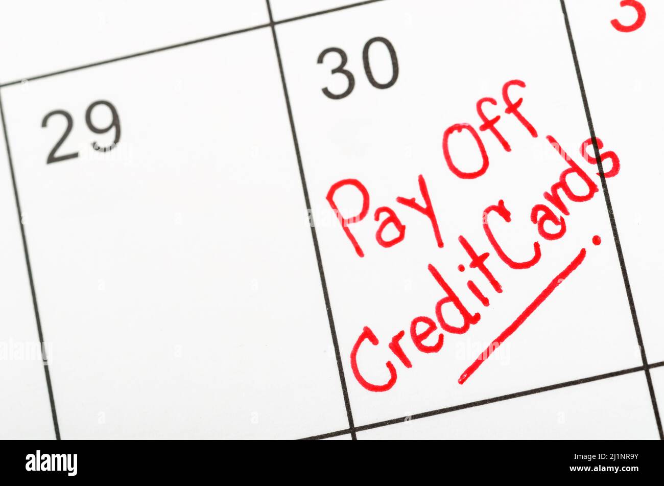 Die Worte Pay off Kreditkarten geschrieben auf einem Kalender. Stockfoto