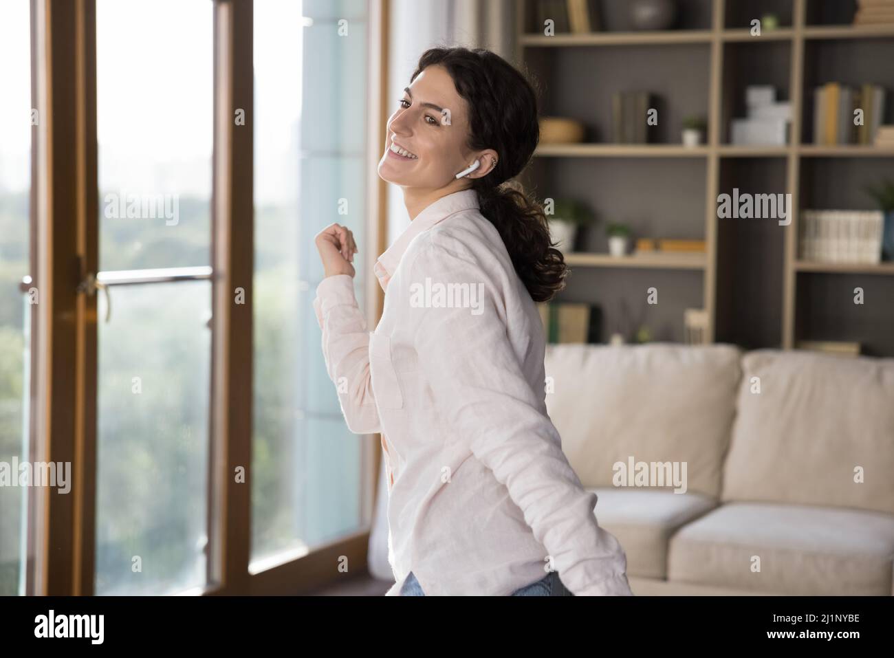 Fröhliche Mädchen mit Ohrhörer im Ohr genießen Lieblingslieder, Stockfoto