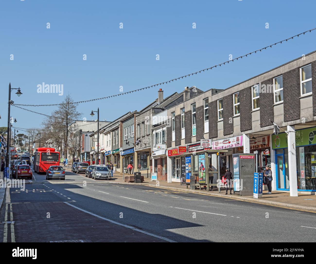 Fore Street in der kornischen Stadt Saltash. Unabhängige Geschäfte überleben neben Imbissbuden, Wohltätigkeitsläden und Friseuren. Es ist die ‘High Street’ o Stockfoto