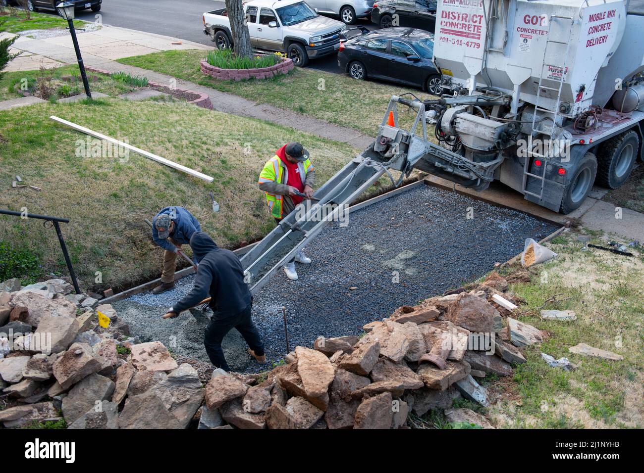 Arbeiter, die eine neue Zufahrt in einem Haus in Maryland USA gießen Beton wird über Drahtgeflecht und Kies gelegt, um die fertige Oberfläche stark zu machen Stockfoto