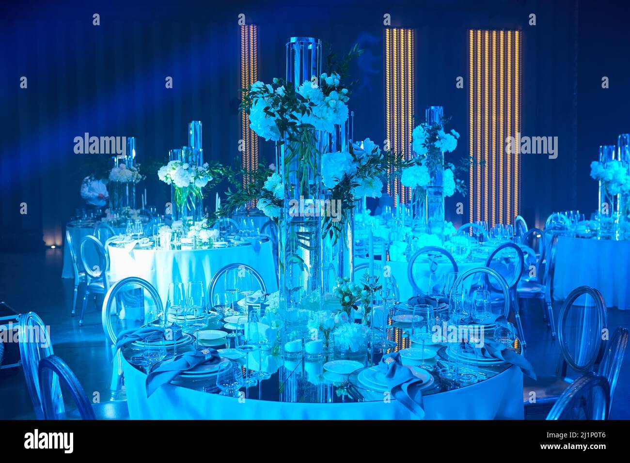 Tischaufbau in blauem Licht. Bereit für die Veranstaltung. Stockfoto