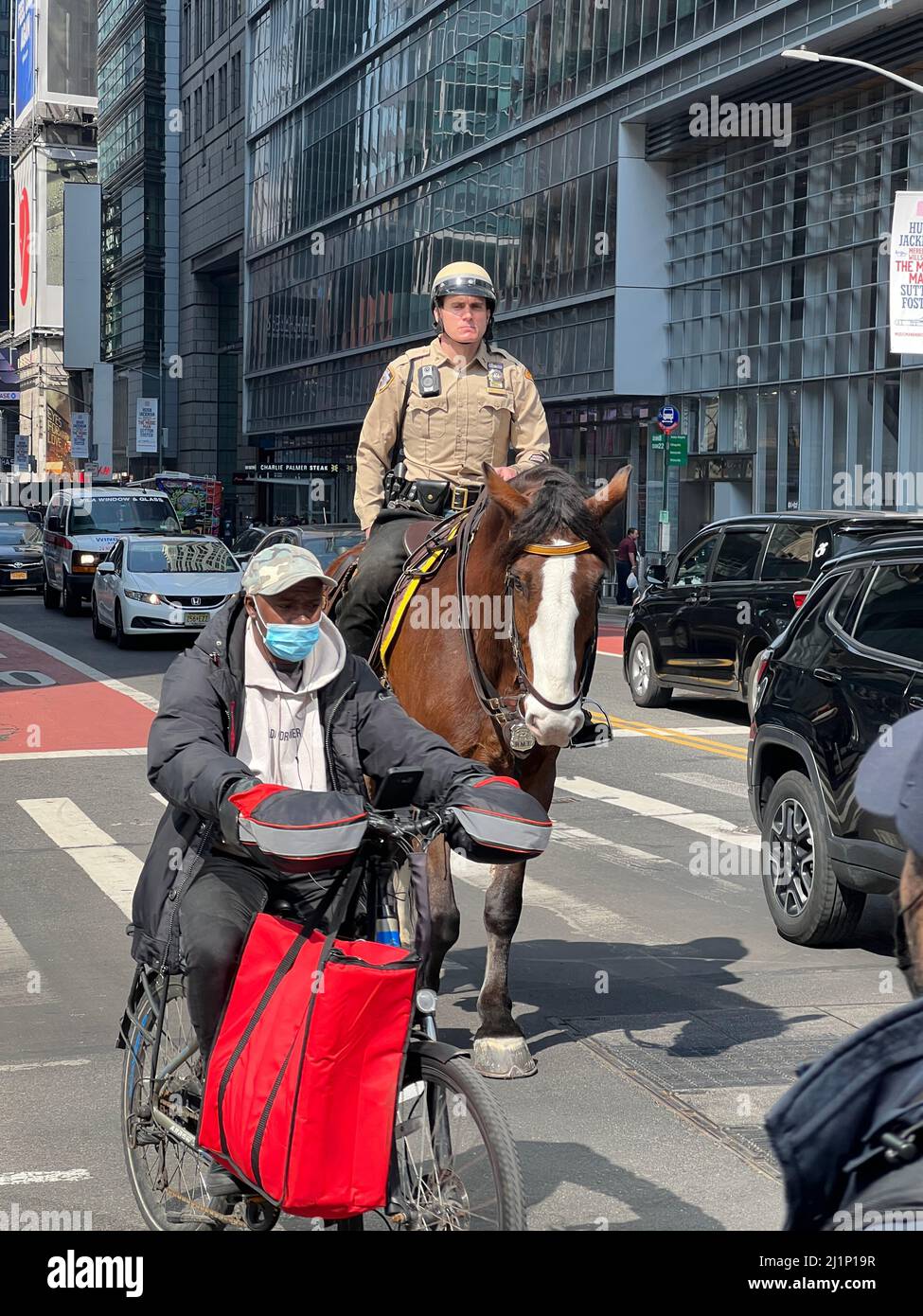 Reiten Offizier auf dem Pferderücken entlang der 42. Street an Fahrrädern und Autos in Midtown Manhattan, New York City. Stockfoto