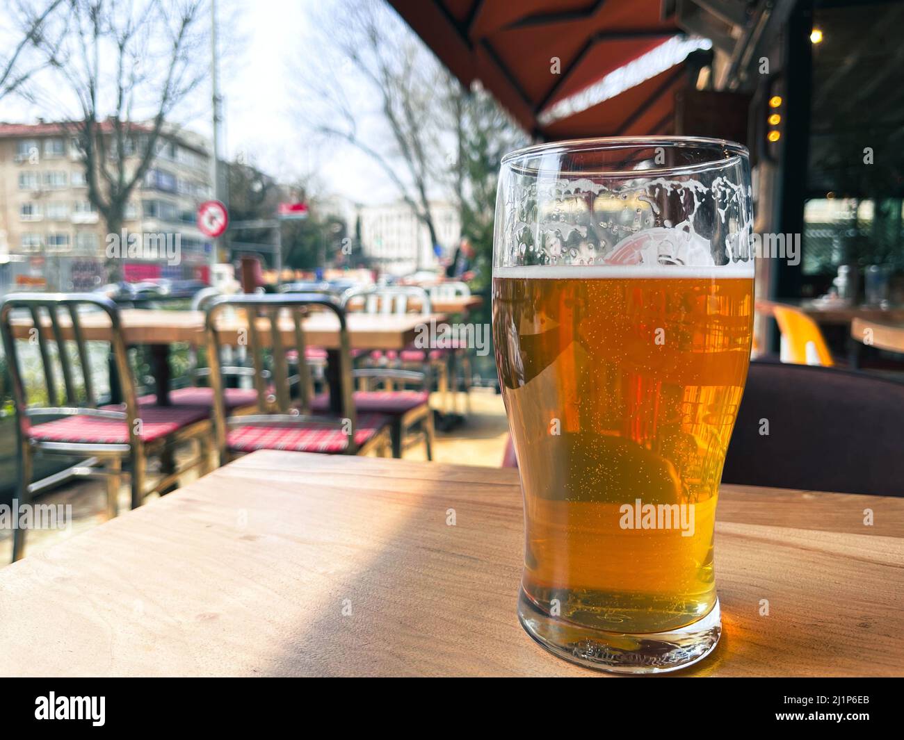 Nahaufnahme eines Pint-Glases Amber Ale-Bier auf der Außenterrasse eines Pubs mit Platz für Text auf der linken Seite. Stockfoto