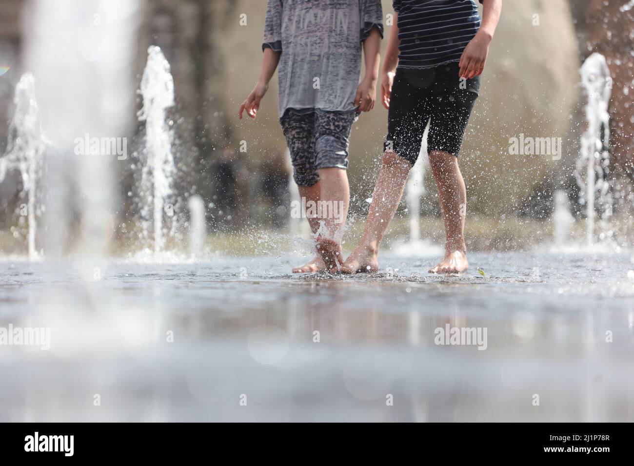 Aschersleben, Deutschland. 27. März 2022. Eine Wasserfontäne sorgt für Erfrischung in einem Stadtpark in Herrenbreite. Bei strahlendem Sonnenschein und warmen Temperaturen konnten viele Besucher den Frühling genießen. Quelle: Matthias Bein/dpa-Zentralbild/ZB/dpa/Alamy Live News Stockfoto