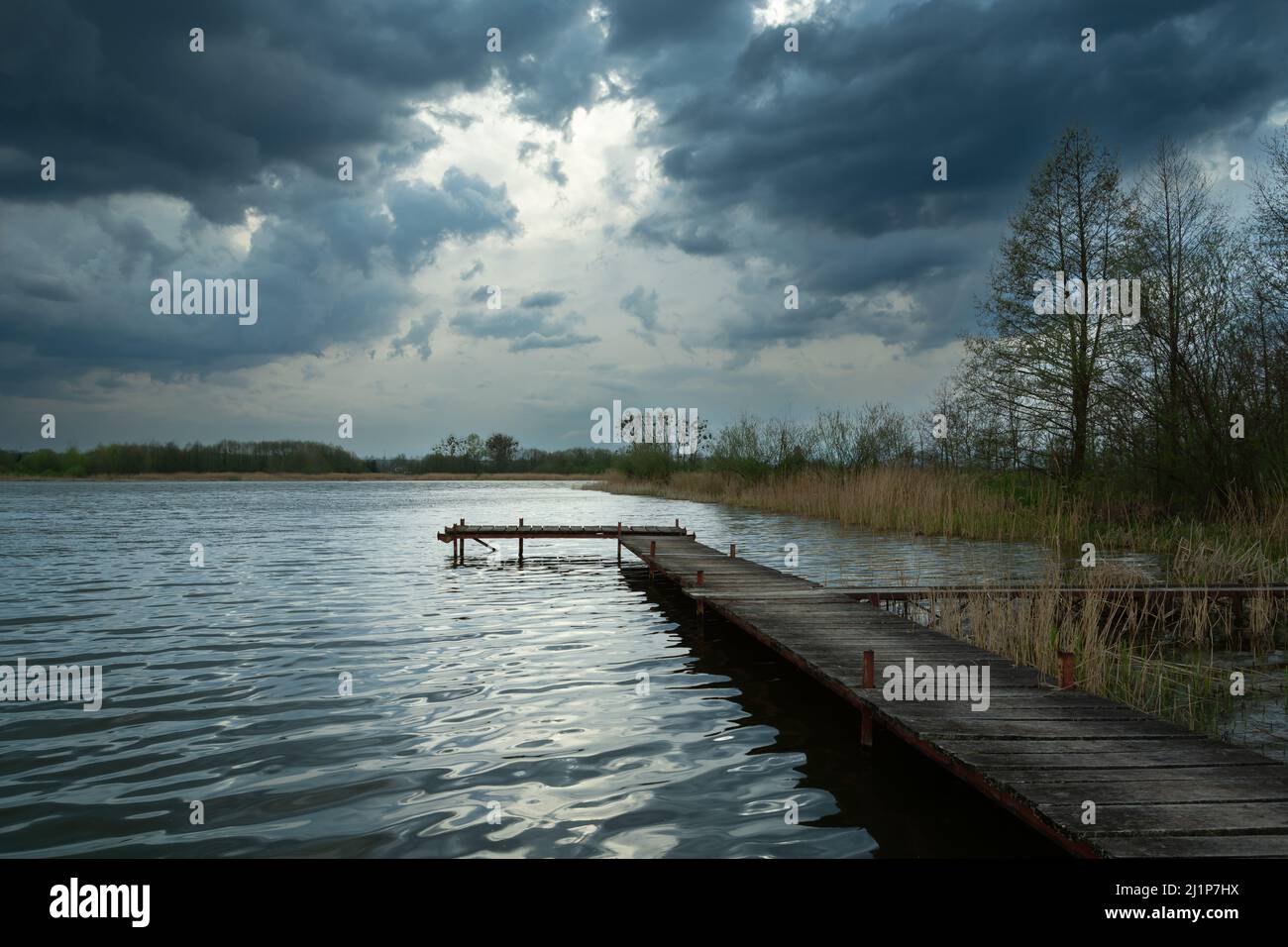 Hölzerner Steg in einem See und wolkenverhegter Himmel, Stankow, Polen Stockfoto