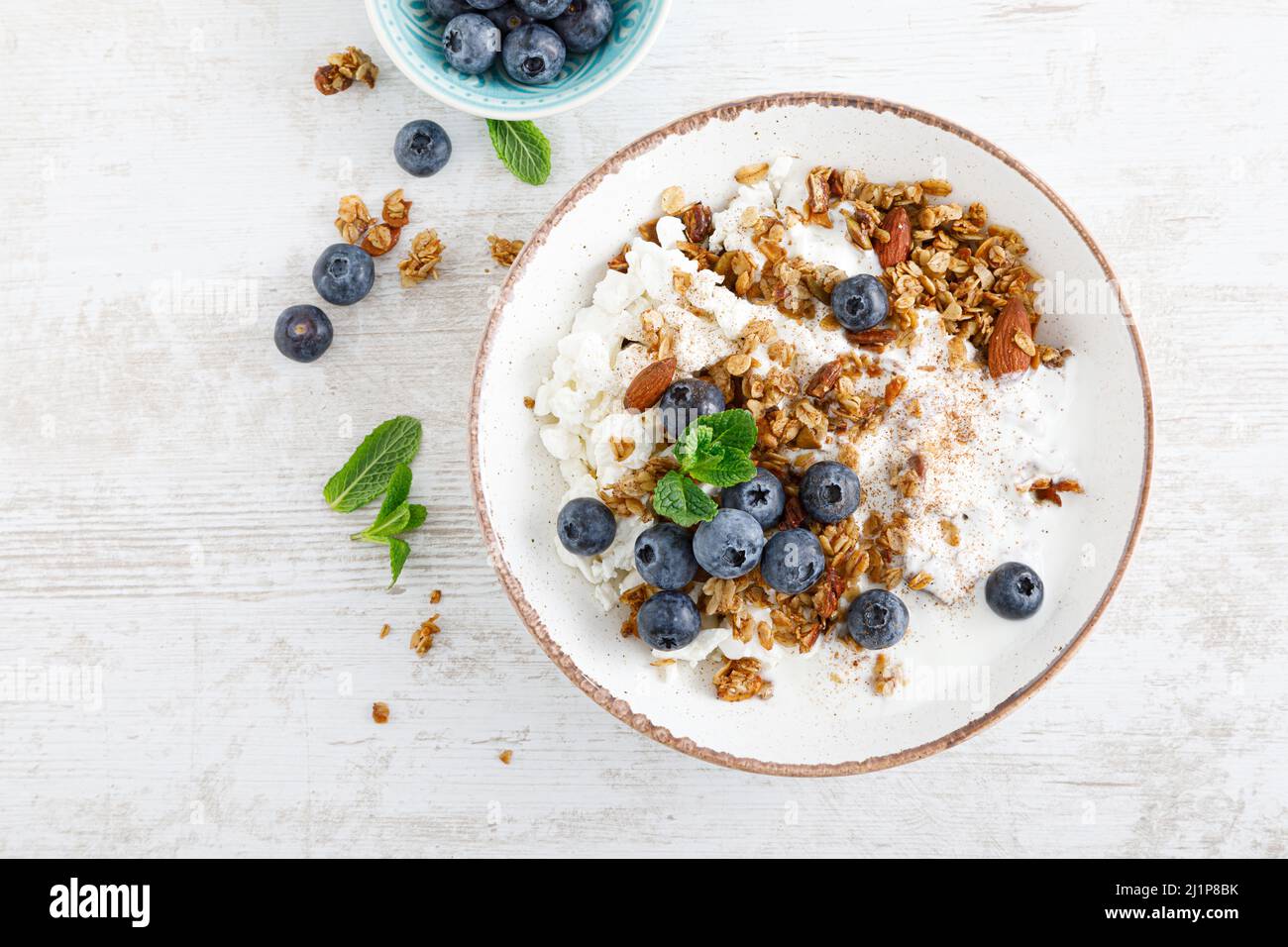 Schüssel Müsli mit frischer Heidelbeere, Quark oder Quark, Joghurt und Nüssen. Gesunde Ernährung. Frühstück. Draufsicht Stockfoto