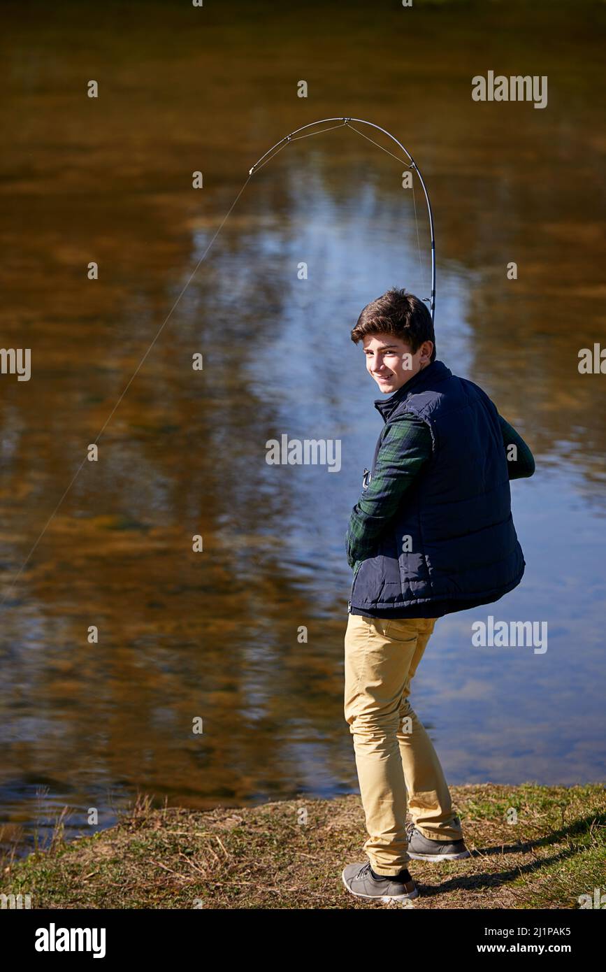 Fische zittern, wenn sie meinen Namen hören. Aufnahme eines Jungen, der an einem See angeln soll. Stockfoto