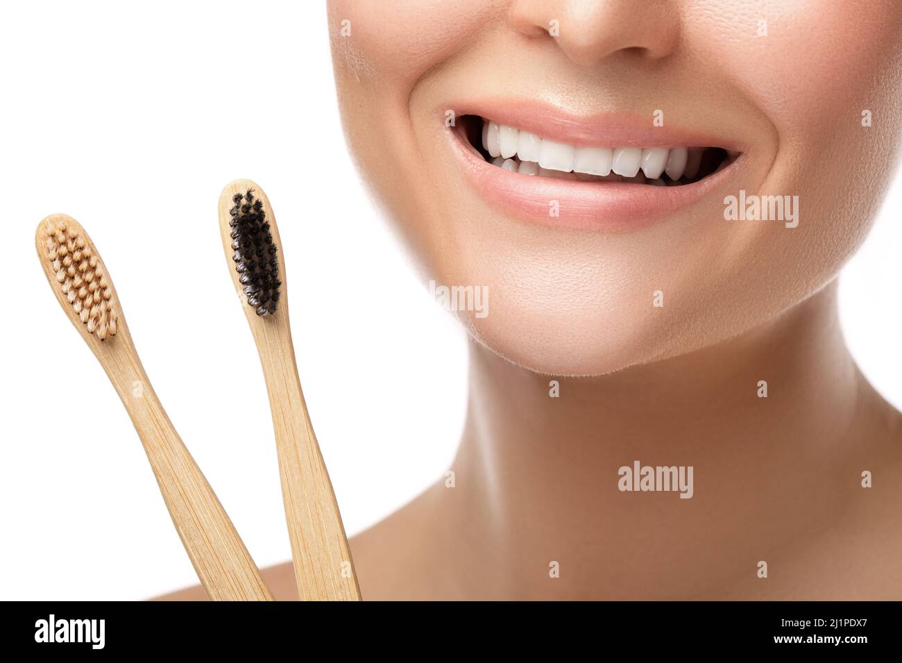 Weiblicher Mund mit weißen Zähnen und Bambuszahnbürsten Stockfoto