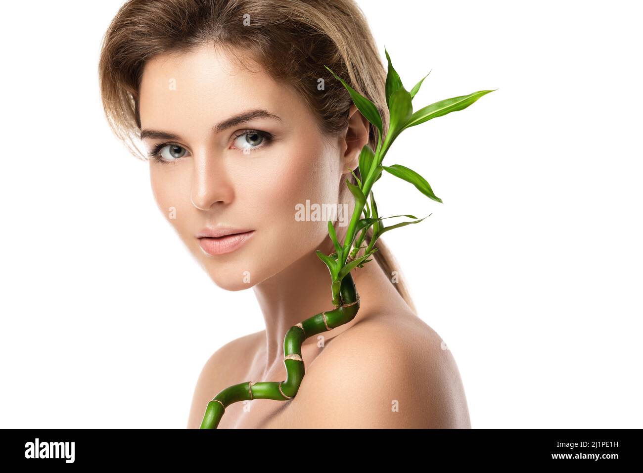 Junge schöne Frau mit einem grünen Bambuszweig Stockfoto
