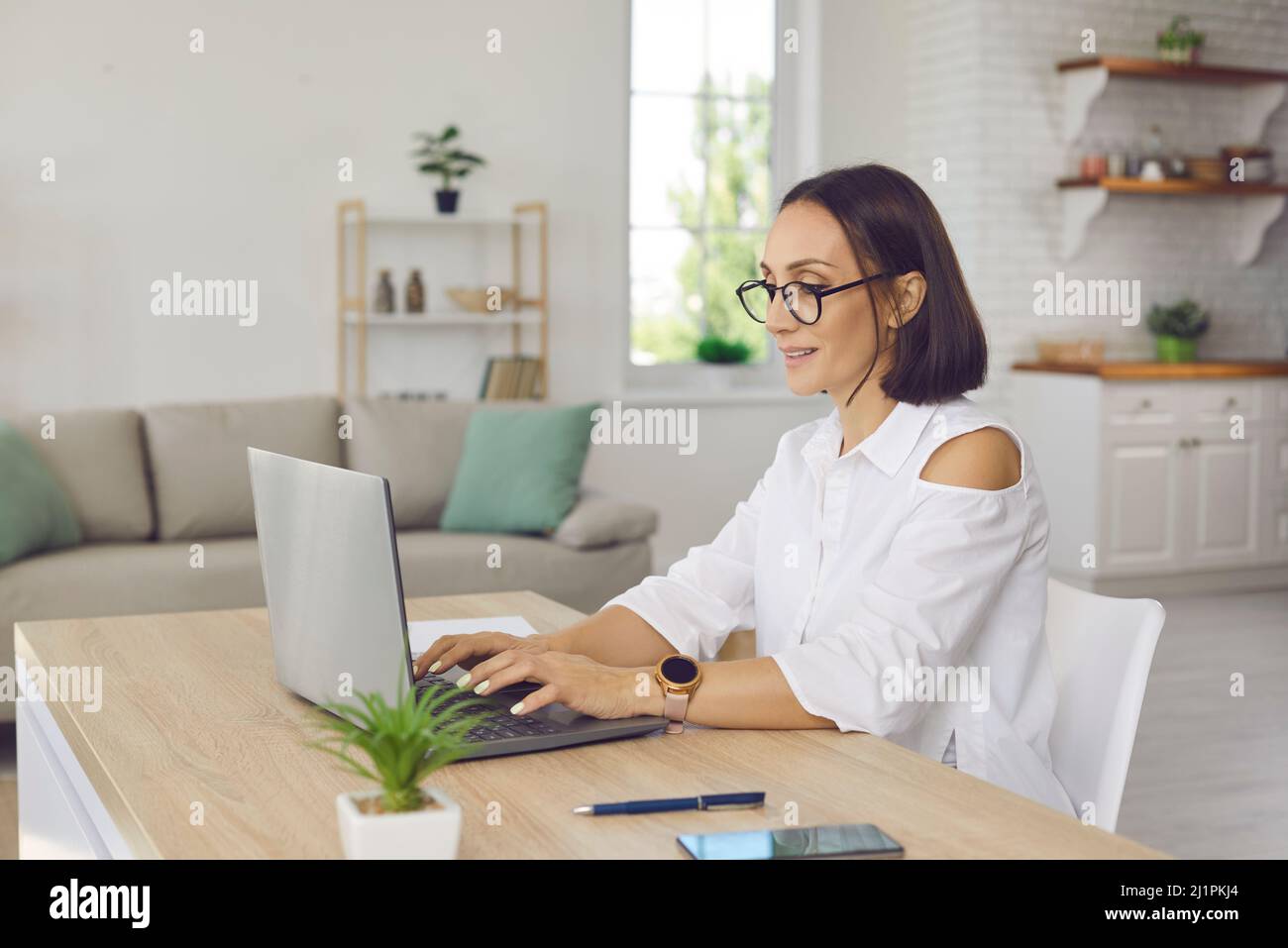 Frau arbeitet online am Laptop im Heimbüro Stockfoto