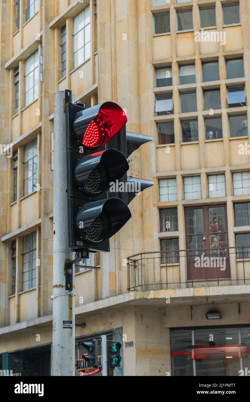 Schwarze Ampel mit roter Ampel in der Stadt Pereira-Kolumbien, braunes Gebäude im Hintergrund. Stoppschild. Verkehrssicherheitskonzept. Verkehr si Stockfoto