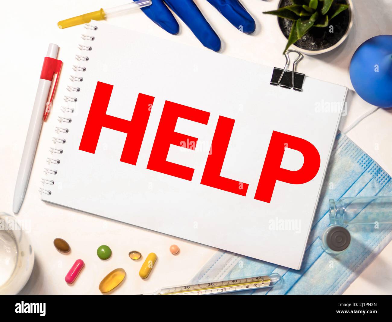 Das Wort Hilfe, auf einem Pflaster geschrieben ein Stück medizinisches Material, das verwendet wird, um eine Wunde zu bedecken. Weiße blanke Baumwolle isoliert auf einer schwarzen Oberfläche. Stockfoto