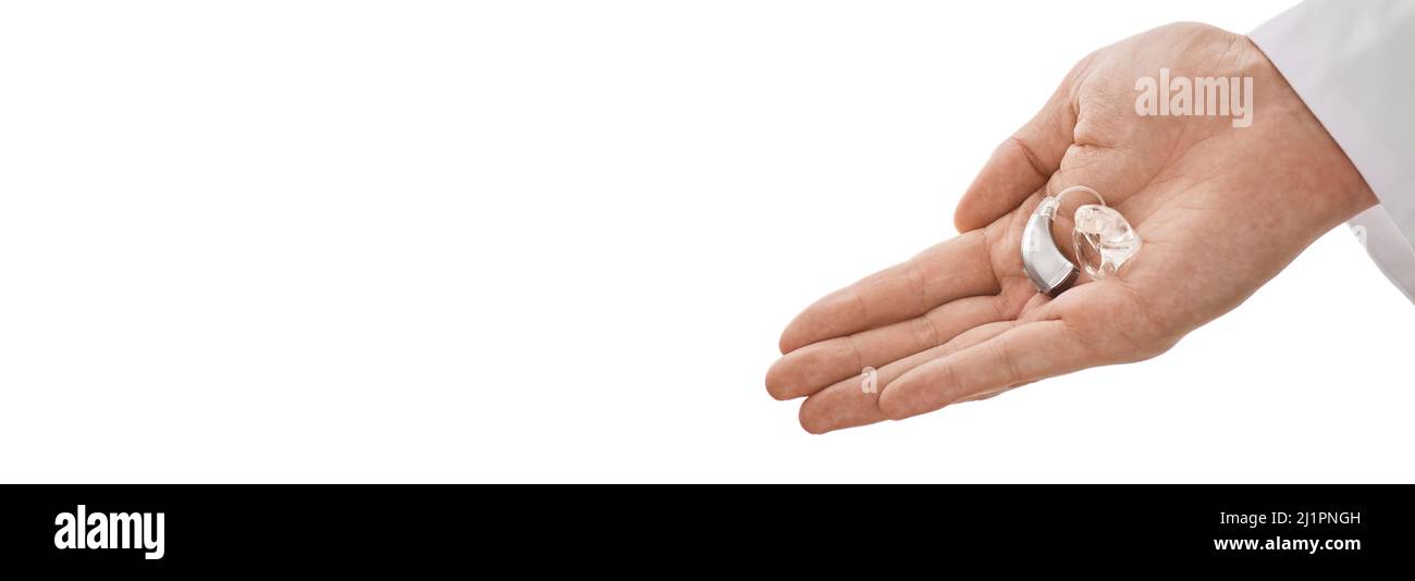 Hörgerät in der Hand eines Arztes, das dem hörgeschädigten Patienten zur Behandlung des Hörvermögens zur Verfügung gestellt wird. Hörlösungen, BTE-Hörgerät Stockfoto